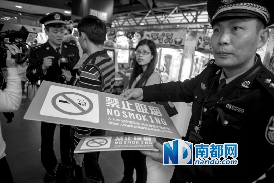 <p>    ↓3月1日，控烟工作者在派发禁烟标志。</p>