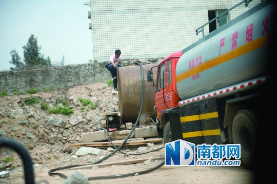 <p>    装满油的油罐车驶到山寨加油站，工作人员爬到油罐上，准备把油罐车里的油输入其中。</p>