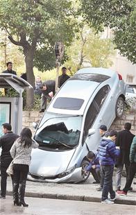 楚天都市报讯 （记者林永俊 黄士峰）女司机停车时，轿车直接撞开铁栅栏，一头栽下落差近2米的路基。昨日中午，汉阳知音东村公交车站旁发生的这起事故，让路人惊诧不已。