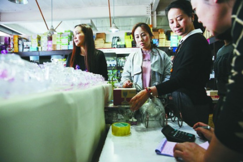  3月30日，某酒店用品批发市场内，为新家购置用品的顾女士(右二)与店老板砍价。